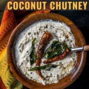 Coconut chutney in a brown bowl tempered with red chilies, curry leaves and mustard seeds