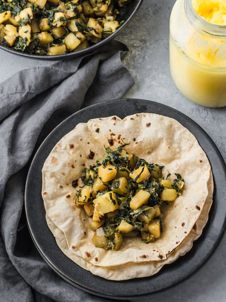 Aloo methi served with chapatis/rotis in a black plate
