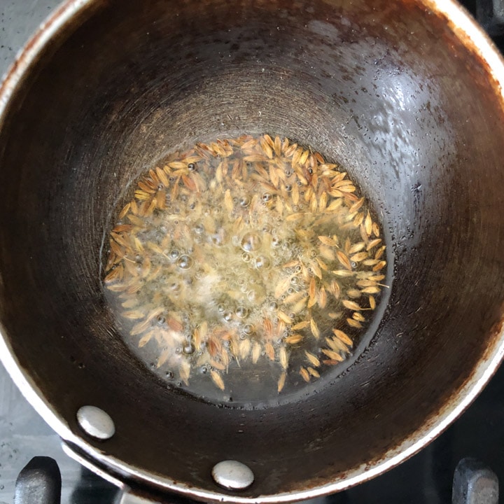 Cumin seeds are added to hot oil