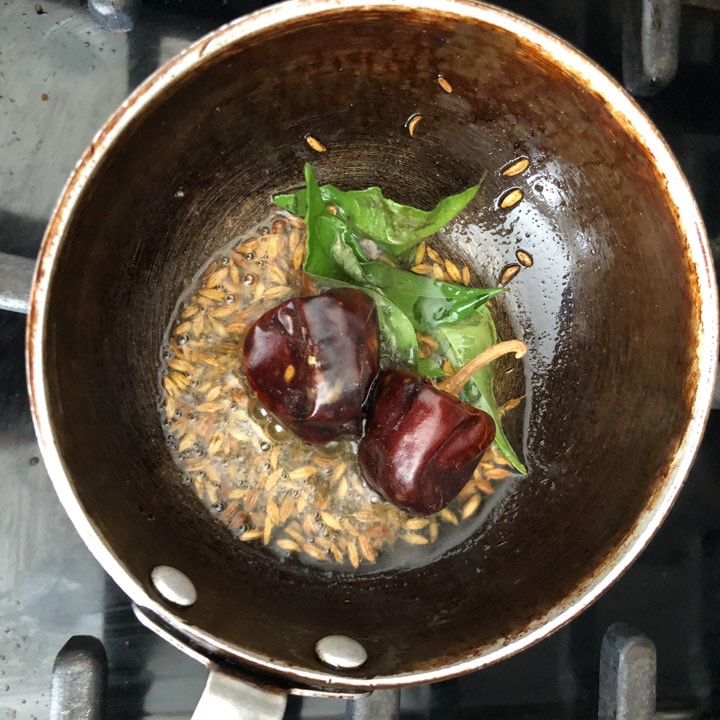 Add curry leaves, chilies, and asafoetida to the tempering