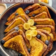 A silver pan with slices of french toast with some bananas and blueberries topping the toast and the words the best french toast at the top.