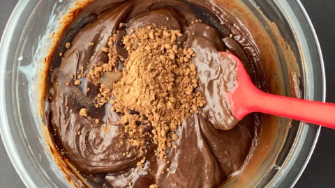 Vanilla essence and cocoa powder added to chocolate mixture in a glass bowl