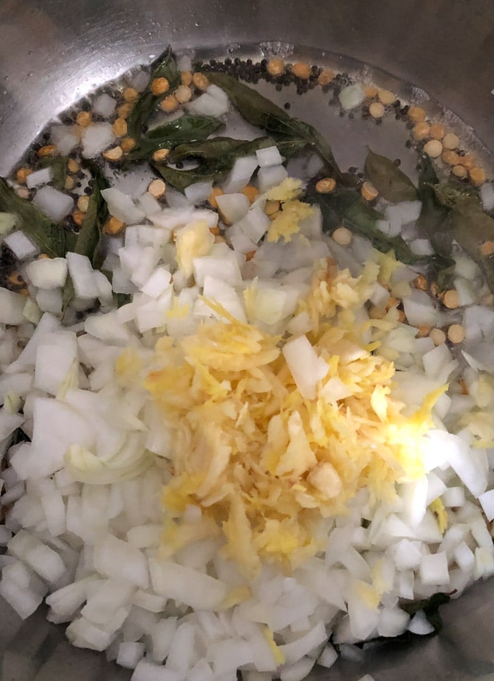 Adding onions and garlic-ginger paste to a tempering of curry leaves