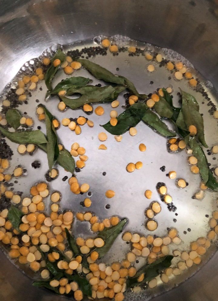 Adding curry leaves and channa dal to a tempering of mustard seeds