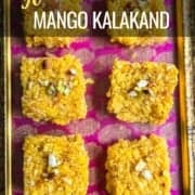 6 pieces of mango kalakand placed on a pink and golden tray