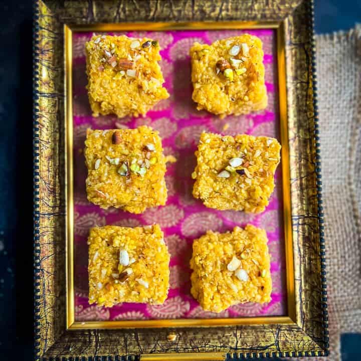 6 pieces of Mango kalakand placed in a pink and gold tray