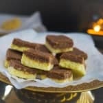 Chocolate barfi pieces stacked on parchment paper