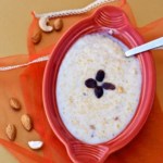 Cracked wheat payasam served with a red bowl with a spoon in it
