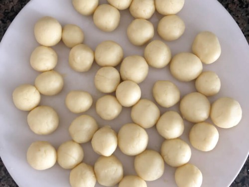 Small rolled balls of dough on a white plate.