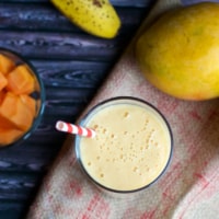 Papaya mango smoothie with a straw