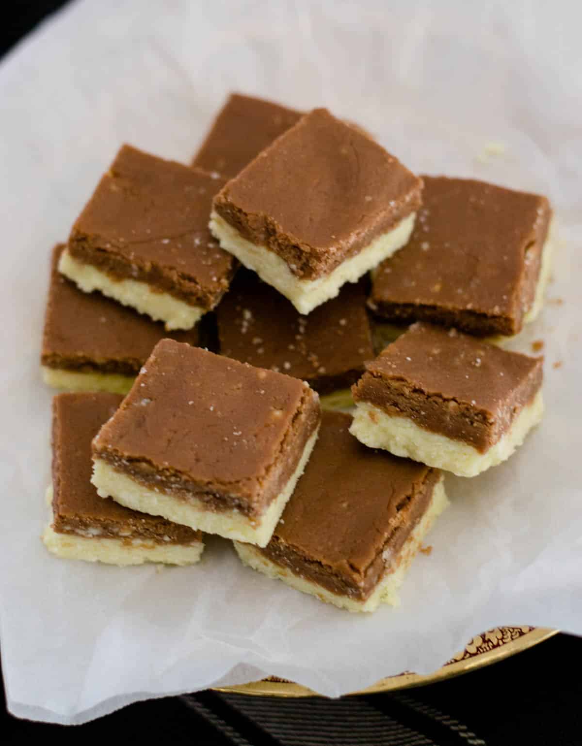 Chocolate barfi pieces stacked on parchment paper
