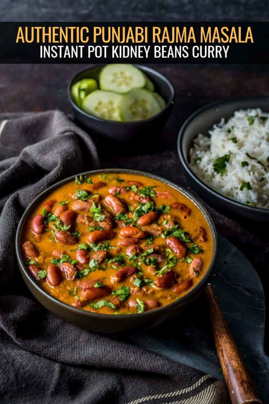 Punjabi rajma masala served in a black bowl accompanied with rice and cucumber slices