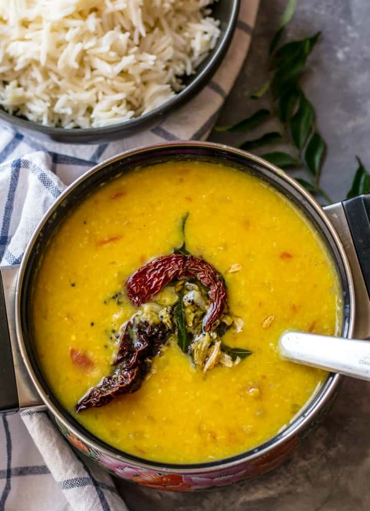 Tadka dal served in a black bowl along with rice