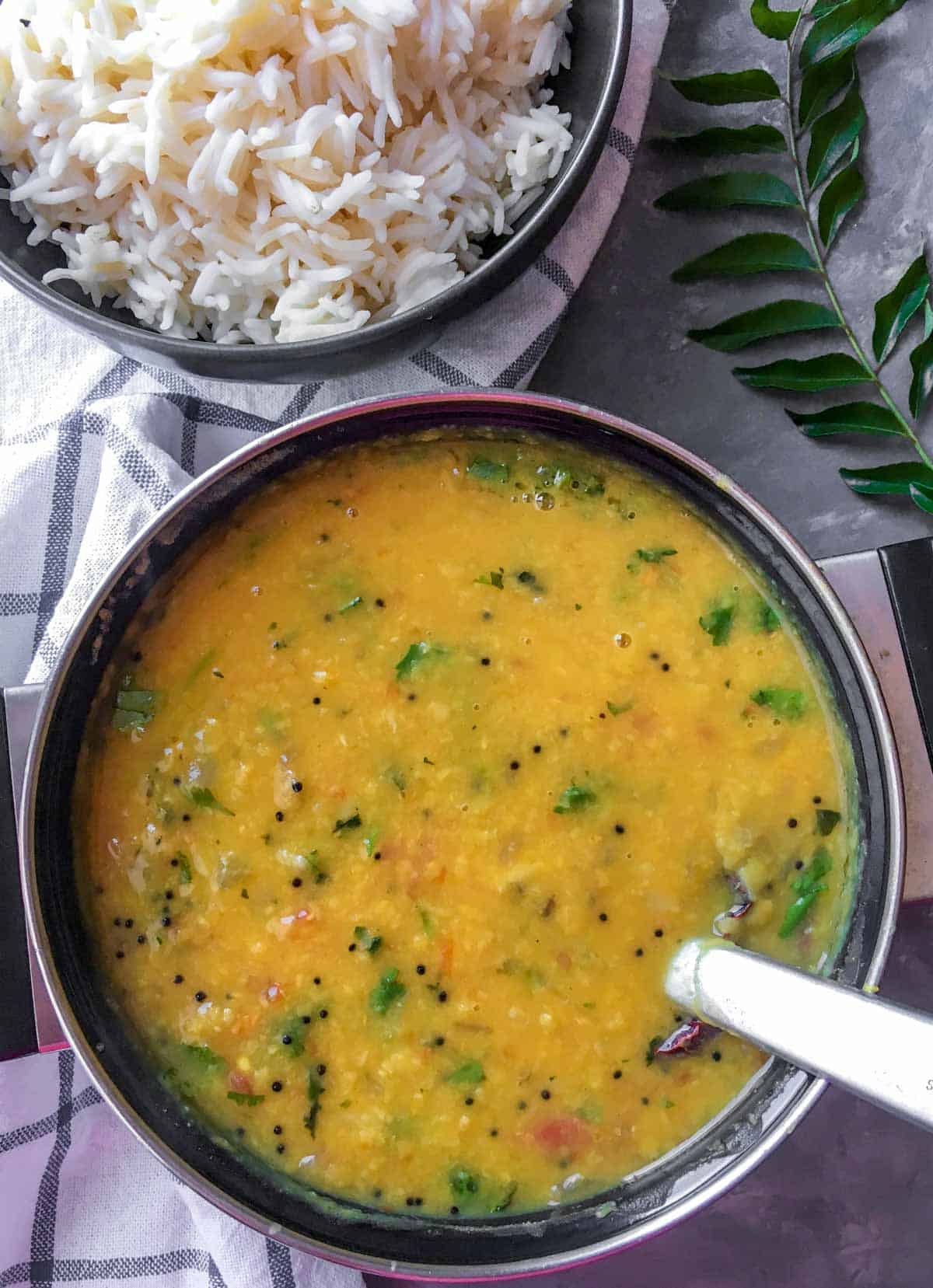 Tadka dal in a black bowl served with rice