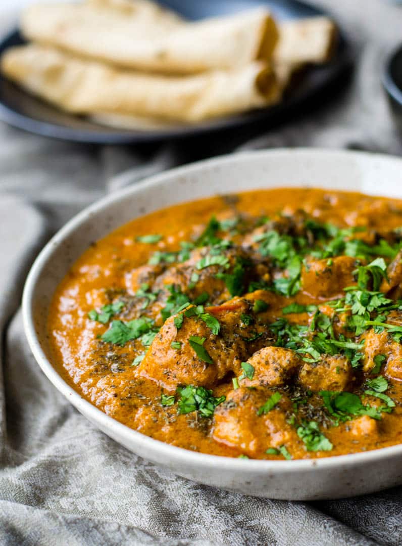 Authentic tasting Indian Butter Chicken Recipe garnished with coriander leaves.