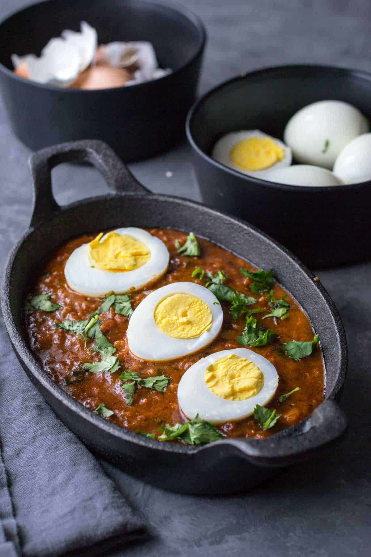Egg curry served in a black serving bowl