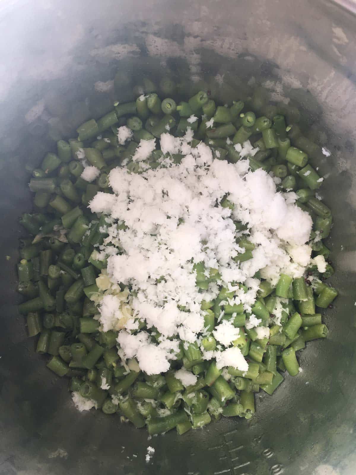 Cooked green beans with freshly grated coconut on top in an Instant Pot