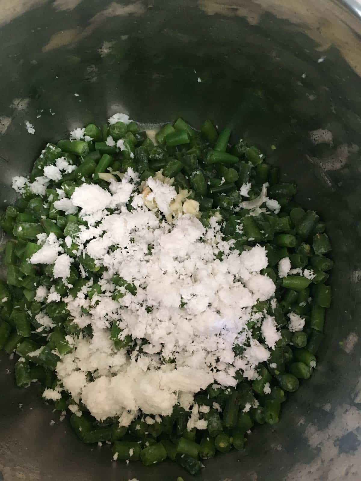 Green beans along with grated coconut in an Instant Pot