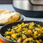 Aloo methi served in a black bowl accompanied with rotis