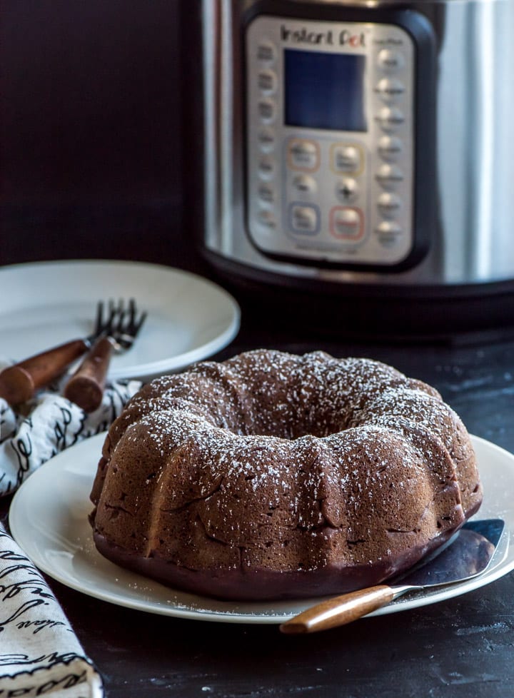 Date cake on white plate with Instant Pot in the background