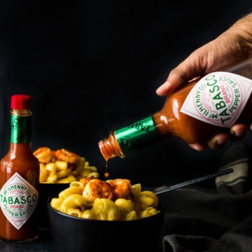 TABASCO sauce being poured over a bowl of Mac and Cheese
