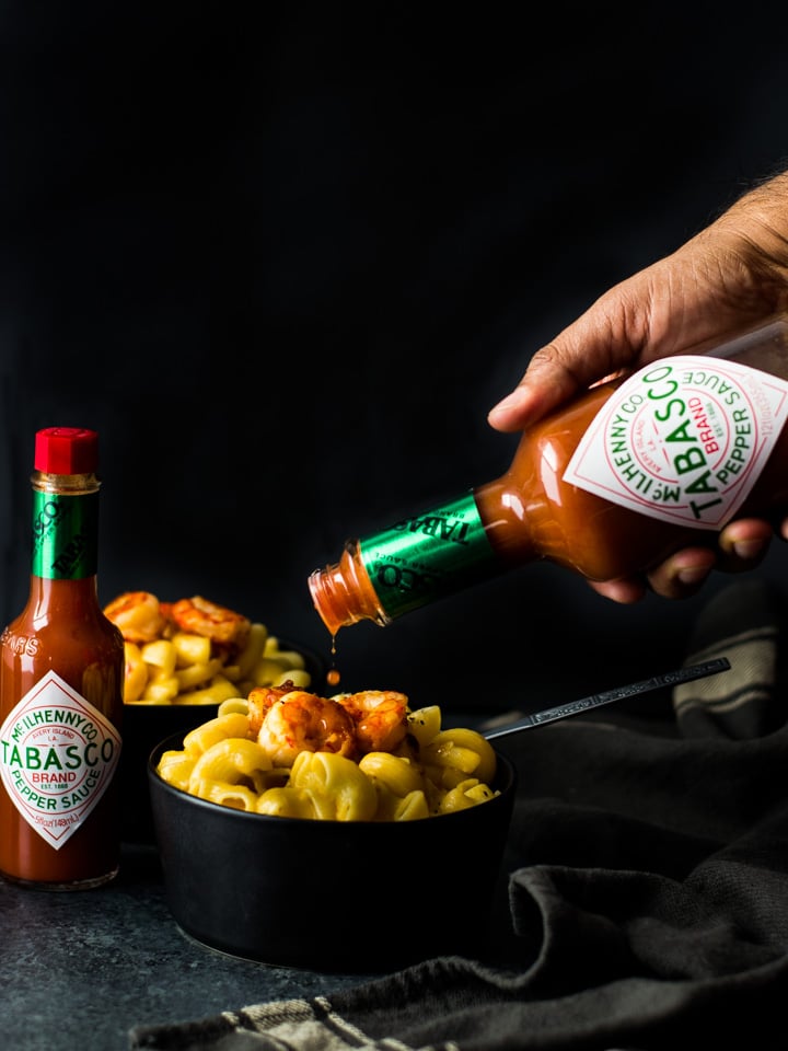 TABASCO sauce being poured over a bowl of Mac and Cheese