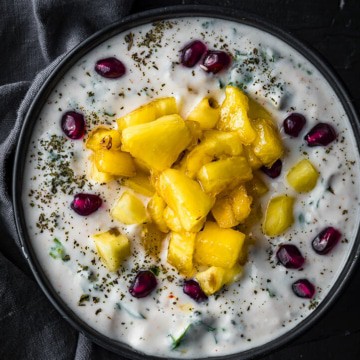 An overhead shot of pineapple raita topped with pomegranate seeds