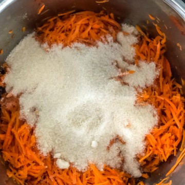 Adding sugar to grated carrots