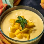 Mango raita served in a glass bowl and garnished with mint leaves