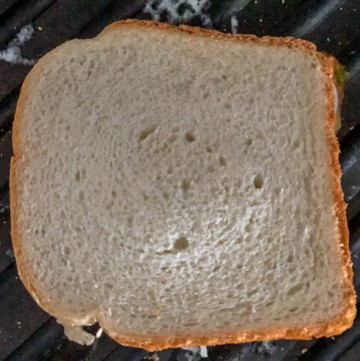 Place the sandwich on a pan with butter on it.