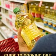 A person holding a bottle of oil in grocery store