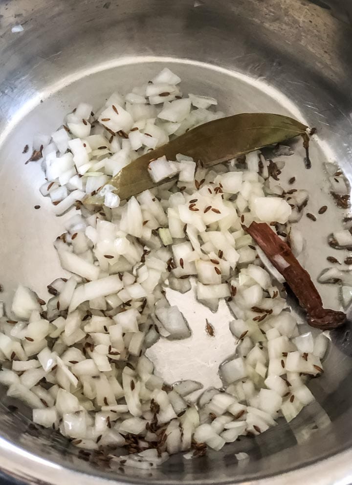 Onions are added in the steel insert of an Instant Pot