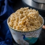 Brown rice served in a white bowl with Instant Pot on the side