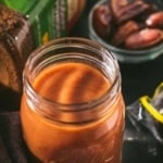 An overhead shot of tamarind date chutney served in a glass bottle