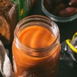 An overhead shot of tamarind date chutney served in a glass bottle