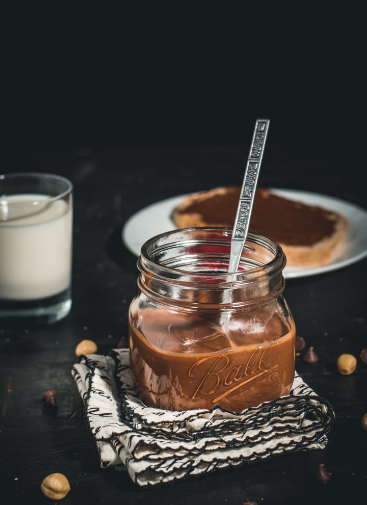 A glass jar filled with chocolate hazelnut spread