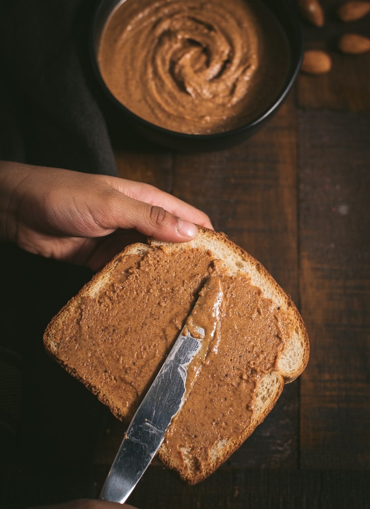 Spreading almond butter on a slice of bread