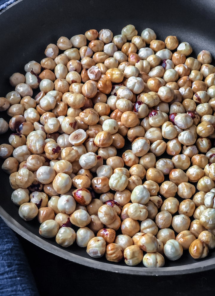 Roasted hazelnuts being cooled in a pan
