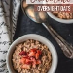 chocolate overnight oats topped with strawberries served in white bowl