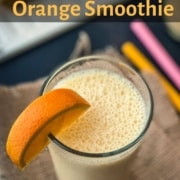 A large glass of orange smoothie with an orange wedge on the left side rim of the glass and the words orange smoothie in orange at the top.