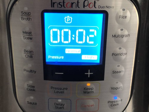 An Instant pot with 2 minutes showing on the panel.