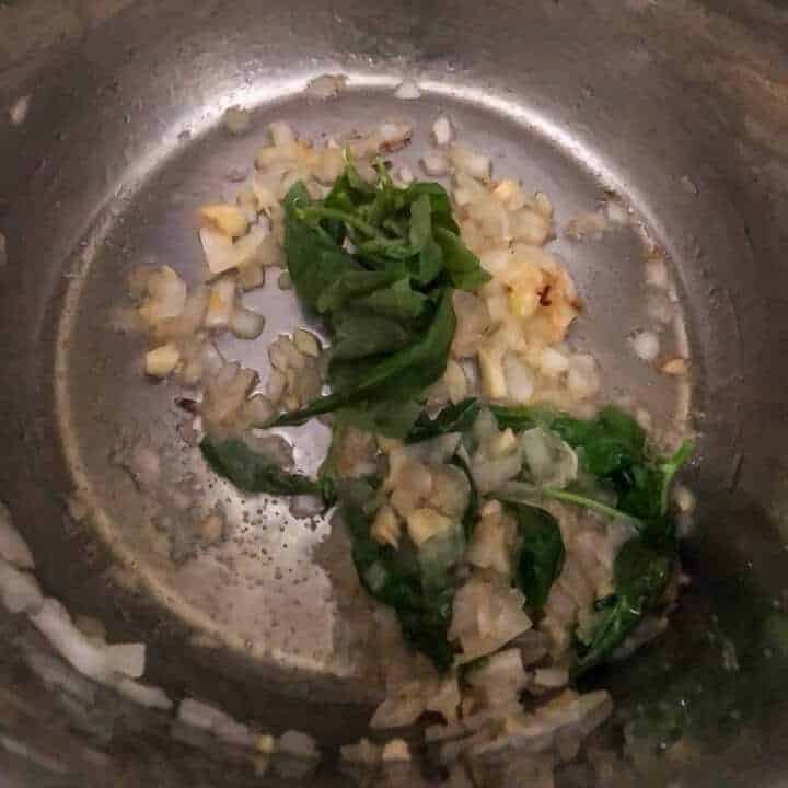 Garlic, onion, and basil in the base of the instant pot.