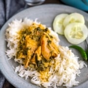 A grey plate with rice topped with instant pot methi murgh with a side of cucumbers and the words instant pot methi murgh at the bottom.