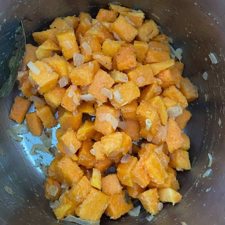The instant pot with butternut squash cubes tossed with the aromatics.