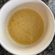 A white bowl with a frothy egg mixture.