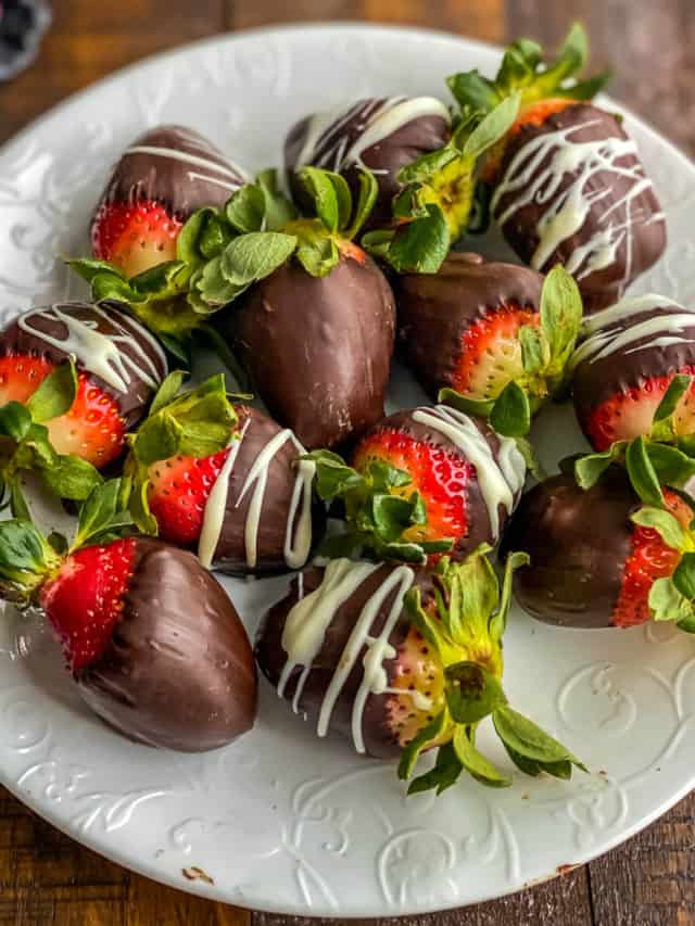 A white plate with chocolate dipped strawberries filling the plate.
