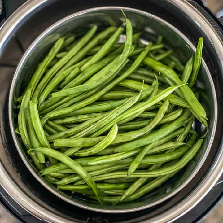 An instant pot with fresh green beans.