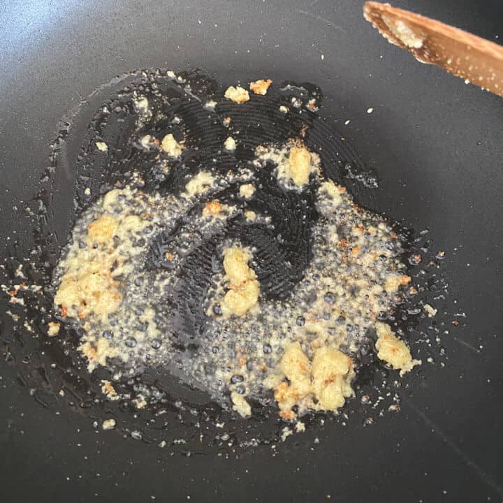 A skillet with oil and garlic chili paste.