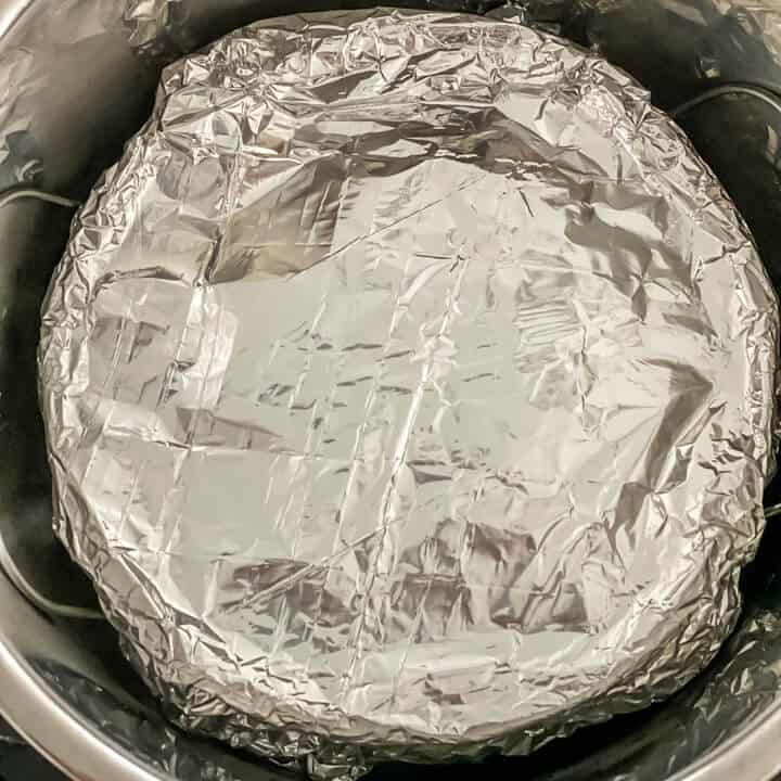 Foil covered vegetarian lasagna in an instant pot on a trivet.