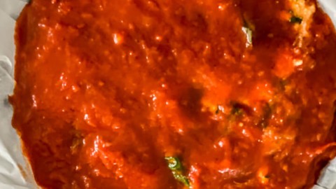 The final layer of marinara sauce on top of the springform pan lasagna.